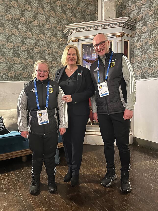 Sabrina Schneider (links) und ihre Trainer Mathias Dolderer (rechts) zusammen mit Bundesinnenministerin Nancy Faeser.