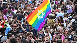Teilnehmer feiern mit einer Regenbogenfahne vor dem Brandenburger Tor bei der 47. Berlin Pride, der Demonstration zum Christopher Street ...