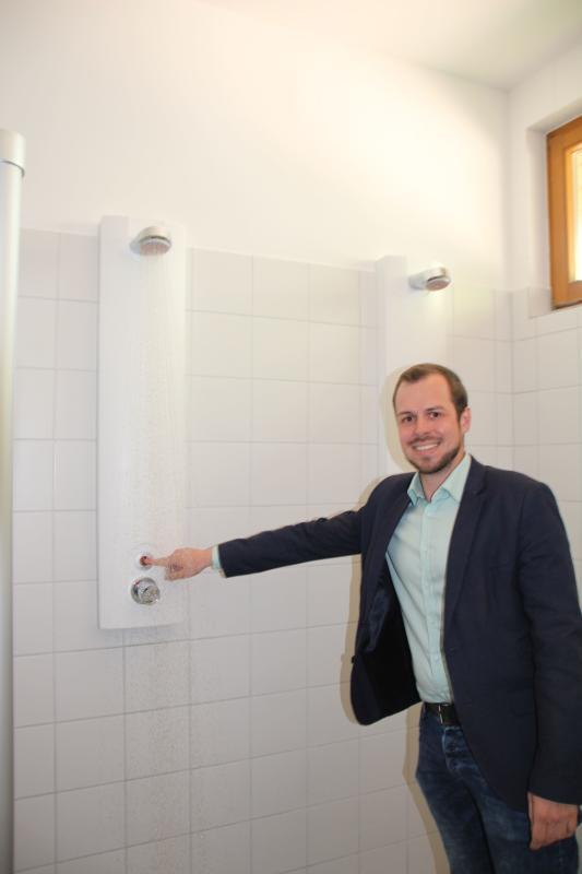 Tourismuschef Andreas Haller testet schon einmal die neuen Duschen, die nun ganz ohne Chips funktionieren.