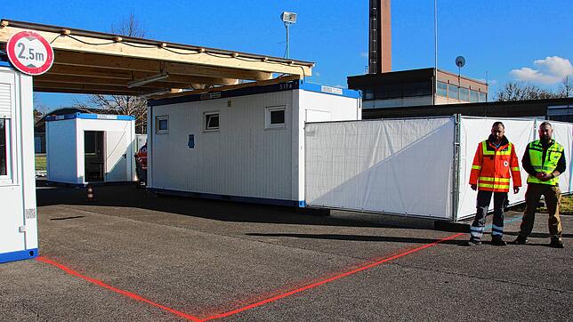 Im Testzentrum fährt der Patient mit dem Auto in den rot markierten Bereich, und ein Arzt macht den Test. Für die Infrastruktur ist ...