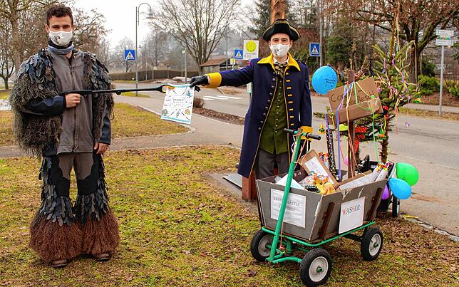 Zunftmeister Tobias Waibel (rechts) und André Mutter demonstrieren am Samstag, wie das Narrenblättle mit ganz viel Abstand übergeben ...