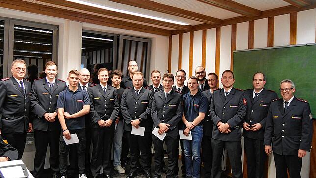 Eingerahmt von Kommandant Stefan Kienzler (links) und dem stellvertretenden Kommandanten Thomas Schleicher (rechts) die Beförderten (von ...