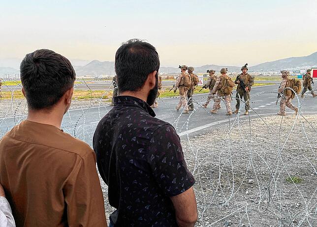 Der Flughafen in Kabul in Afghanistan: US-Soldaten bewachen eine Absperrung am internationalen Flughafen. Afghanen, die vor den Taliban ...