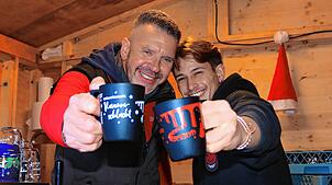 Paul Walter und Petro Caetano vom Hofgut Sternen mit ihren Motiv Weihnachtsmarkttassen gefüllt mit duftendem Winzerglühwein.
