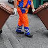 Ein Mitarbeiter der Abfallwirtschaft und Stadtreinigung schiebt eine braune Tonne mit Biomüll zum Müllwagen. Gerade für die unteren ...