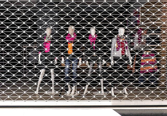 Mannequins stehen während des coronabedingten Lockdowns im Schaufenster eines verriegelten Modegeschäfts.