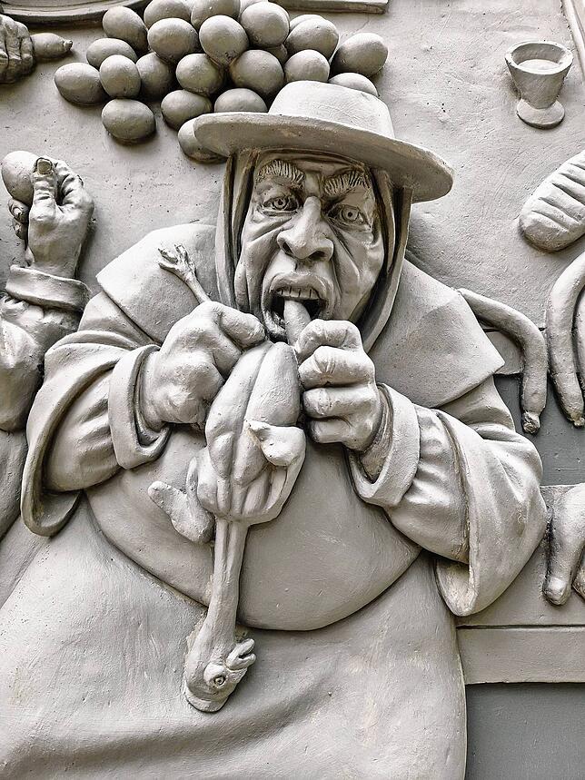 Die Skulptur zeigt in einem Detail auch die Völlerei.