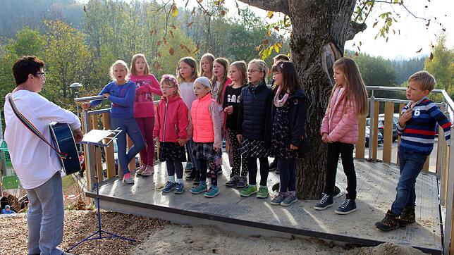 Große Freude herrscht auch bei den kleinen Ramsbergschülern über die Ortsmitte mit dem Spielplatz. Mit Rektorin Maria Baader singen sie ...
