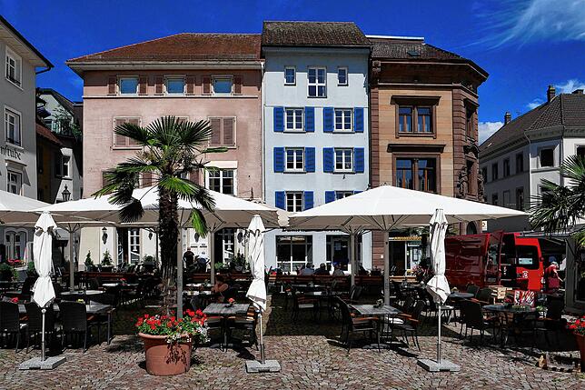 Das heutige Erscheinungsbild des Münsterplatzes mit einem Gasthaus (links), einer Zeitungsredaktion (Mitte) und einer Bankfiliale (rechts).
