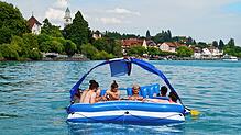 Vor Überlingen lässt sich eine Gruppe junger Männer auf einer XXL-Schwimminsel treiben: Im Sommer tummeln sich viele Menschen auf ...