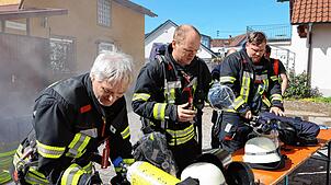 Kurzprüfung vor der Atemschutzübung: Gleich geht es für die Feuerwehrleute aus Salem in das vernebelte Gebäude links im Hintergrund.