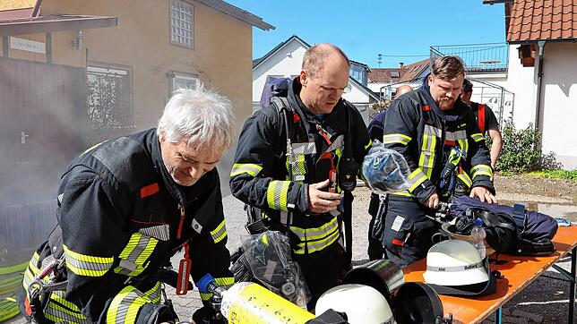 Kurzprüfung vor der Atemschutzübung: Gleich geht es für die Feuerwehrleute aus Salem in das vernebelte Gebäude links im Hintergrund.