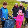 Joah und Grace Fodor halten den Müllsack, während Amelie Fahr einen Müllschnipsle, den sie mit der Zange aufgesammelt hat, hineinwirft. ...