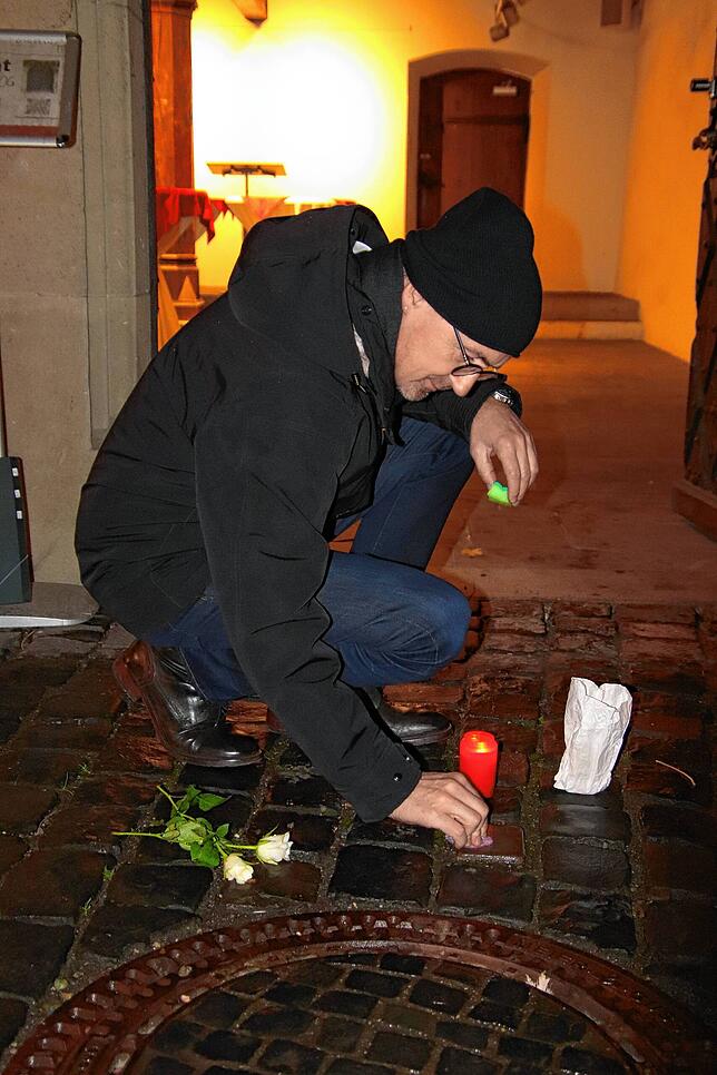 Konstanz‘ Oberbürgermeister Uli Burchardt putzt am Donnerstagabend den Stolperstein vor dem Rathaus.