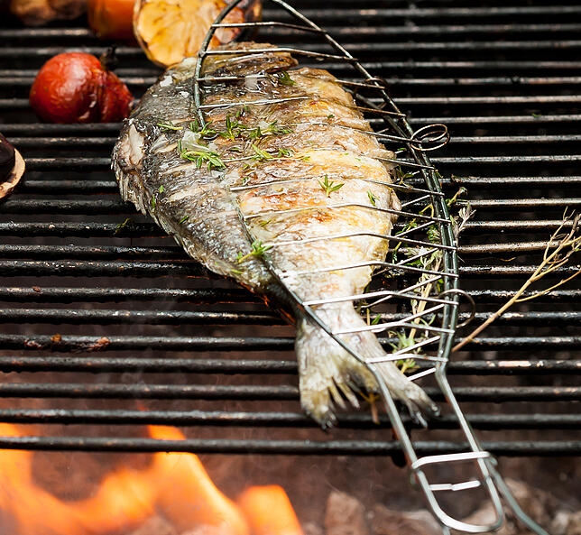 Eine Dorade lässt sich perfekt im Ganzen grillen. Nützlich ist dabei eine Fischgrillzange.