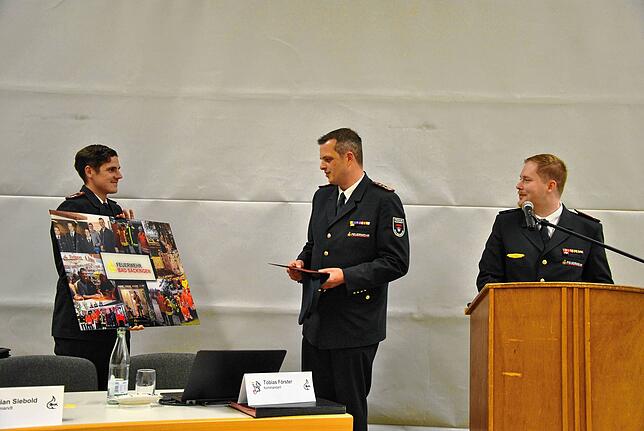 Mark Jagenow überreicht Tobias Förster zum Dank ein Foto der Feuerwehr Bad Säckingen. Mit ihm freut sich auch Christian Siebold.