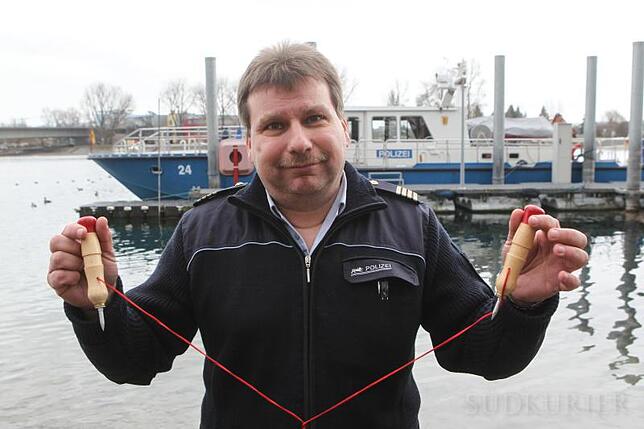 Mario Schinlder zeigt zwei kleine Eispickel, mit denen man sich selbst aus dem Eis befreien kann. Bild: Oliver Hanser