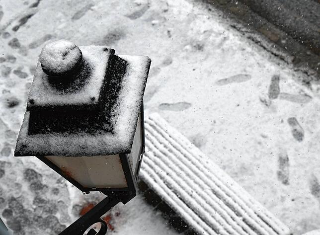 Schnee bedeckt Laternen und die Bank an der Bushaltestelle in der Hauptstraße