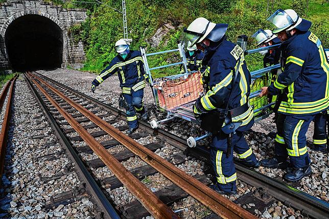 Kräfte der St. Georgener Feuerwehr stellen einen Spezialrollwagen auf die Gleise, um so Material zur Einsatzstelle zu bringen. Im ...