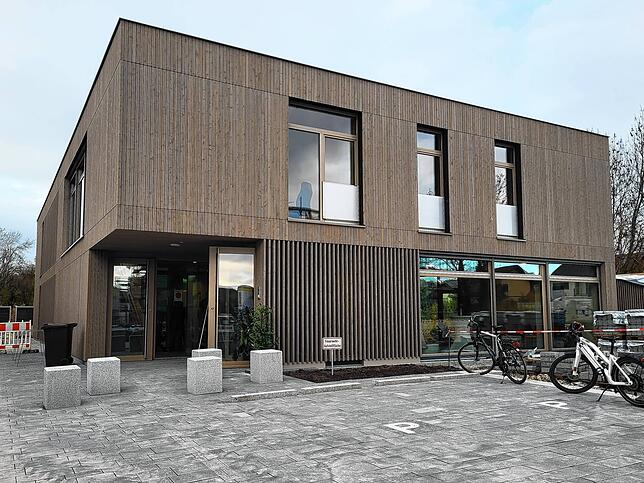Das zweistöckige Gebäude überzeugt mit Wänden aus Holz und vielen Fenster, wodurch die Räume hell und offen wirken.