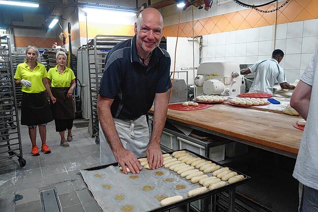 Oliver Herr ist Bäckermeister bei der Bäckerei Grecht und formt hier gerade Einback aus luftigem Hefeteig.