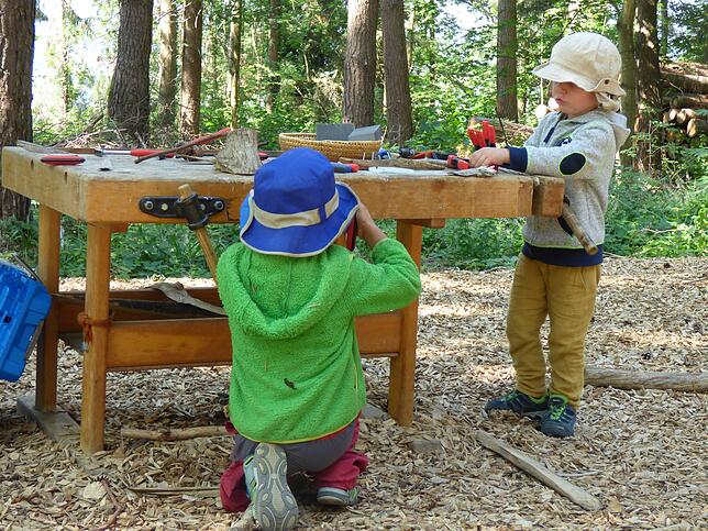 An der neuen Werkbank wird fleißig gewerkelt. Leonardo und Benjamin sind konzentriert an der Arbeit.