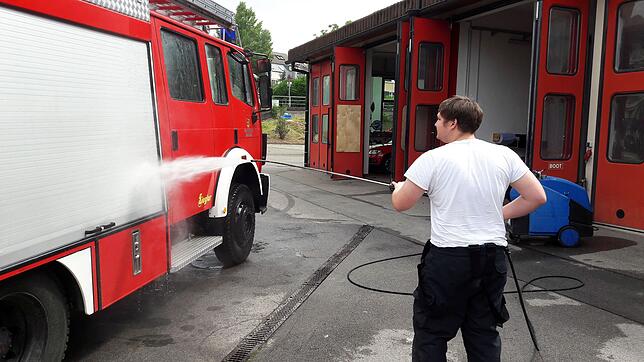 Reinigung nach dem Großeinsatz: Christian Regenscheit befreit das Feuerwehfahrzeu vom Schlamm.