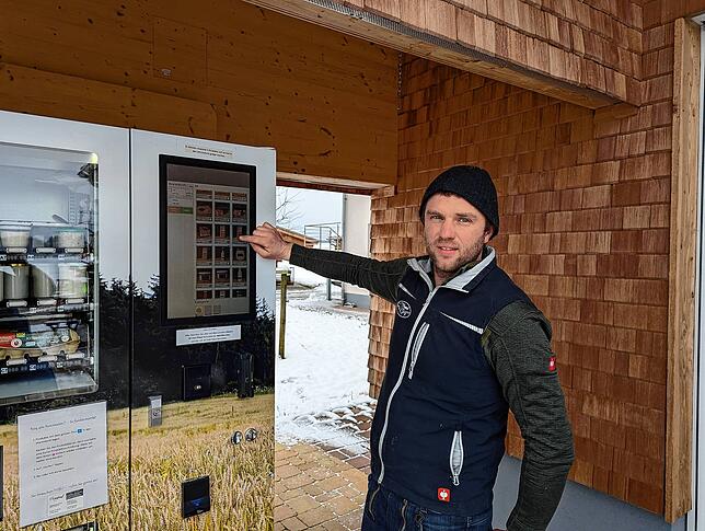Mathias Friedrich vom Breghof zeigt auf die Bedienfläche des Hofautomaten.