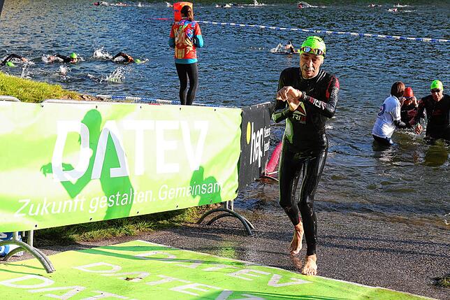 Schnell aus dem Wasser und dabei die Zwischenzeit checken: Fritz Österreich während des Triathlons in Roth