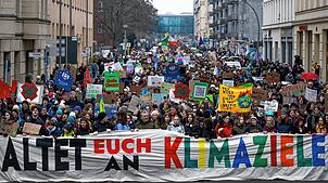 Teilnehmer der Demonstration von Fridays for Future halten ein Transparent mit der Aufschrift „Haltet euch an die Klimaziele“.