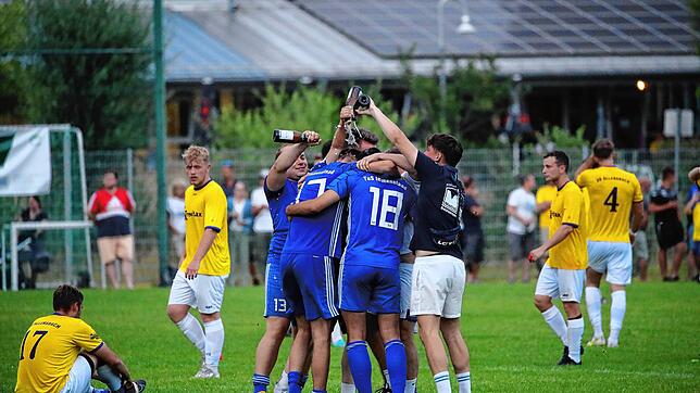 Die Spieler des TuS Immenstaad (blaue Trikots) feiern nach dem Abpfiff den Sieg und den Aufstieg in die Bezirksliga.
