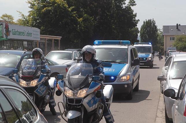 Vor der Trauerfeier: Die Polizeibeamten sind für die Trauernden nur einmal wirklich sichtbar, als sie auf den Parkplatz des Friedhofs ...