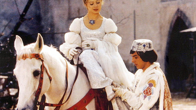 Der Prinz (Pavel Travnicek) passt Aschenbrödel (Libuse Safrankova) im Film "Drei Haselnüsse für Aschenbrödel" den verlorenen Schuh an