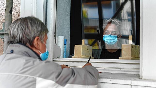 Die Wohnungslosen &ndash; wie hier Dieter Rattke &ndash; werden von Sozialarbeiterin ... durch ein Fenster beraten.