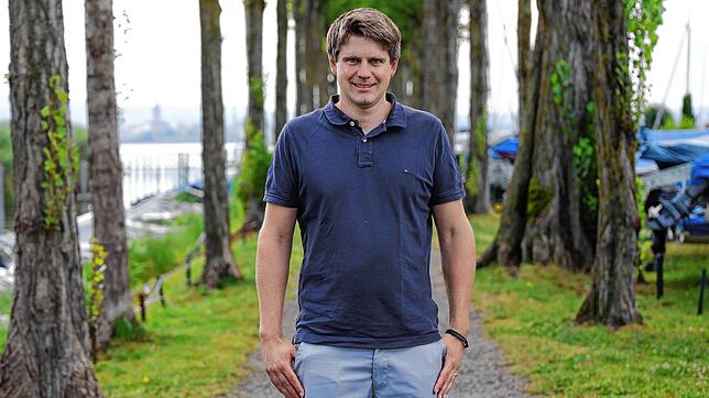Stefan Heck steht am Hafen in Moos, im Hintergrund ist nicht nur der Bodensee, sondern ganz klein auch Radolfzell zu sehen. Moos liegt ...