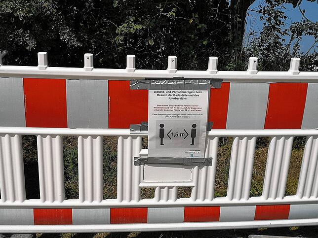 Zettel auf Warnbarken erinnern die Badegäste daran, die Abstands- und Hygieneregeln einzuhalten.
