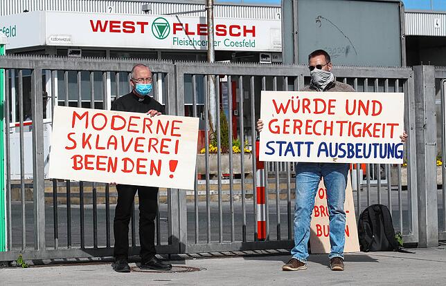 Zwei Demonstranten protestieren vor dem Werkstor von „Westfleisch“ im Kreis Coesfeld gegen die Arbeitsbedingungen in der ...