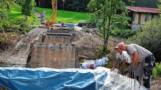 Carmelo Vicino (links) und Ivica Krijan sichern den frisch gegeossenen Beton an der Wutachbrücke in Achdorf vor dem nahenden Regen.