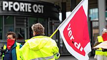 Ein Demonstrant steht mit einer Ver.di Fahne am Stuttgarter Flughafen. Der Warnstreik der Flugsicherheitskräfte wird am Donnerstag an ...