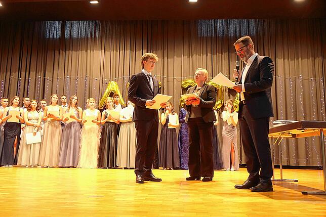 Andreas Andelfinder (r.) und Simone Hägele-Schatz geben Andreas Schamber den Preis.