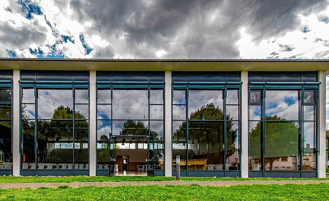 In der Glasfassade des Bürgerhauses der Gemeinde Sauldorf spiegelt sich der Wolkenhimmel. Drinnen werden Hochzeitsvorbereitungen getroffen.