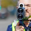 Ein Polizist schaut durch ein Radargerät. Hier ein Symbolbild.