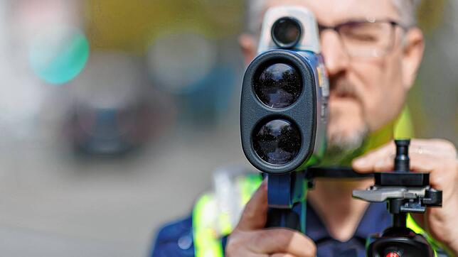 Ein Polizist schaut durch ein Radargerät. Hier ein Symbolbild.