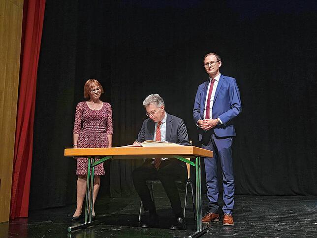 Christoph Heusgen trägt sich in das goldene Buch der Stadt ein. Links Dinah Reimnitz, Vorstandsvorsitzende der ...