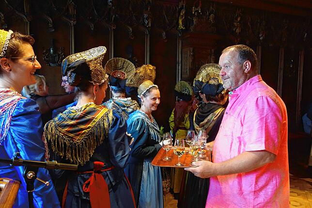 Rollentausch: Martin Keßler serviert den Trachtenfrauen Getränke.
