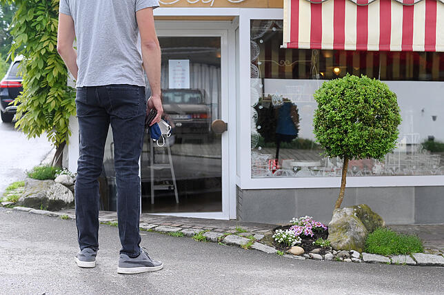 Ein Gast wartet vor dem Café Höpker, damit die Höchstzahl an Personen drinnen bei der Kuchenabholung nicht überschritten wird.