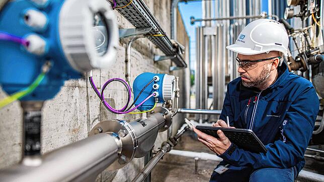 Ein E+H-Mitarbeiter prüft eine Messtechnikanlage bei einem Industriekunden. Foto: E+H