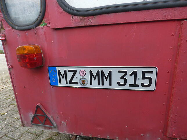Der rote Anhänger auf dem ehemaligen Aldi-Parkplatz hat noch eine altes Nummernschild. Der TÜV ist mit dem April 2017 abgelaufen.