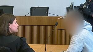 Ein mutmaßlicher Einbrecher sitzt im Stuttgarter Landgericht auf der Anklagebank und berät sich mit seiner Anwältin.