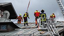 Stuttgart: Einsatzkräfte der Feuerwehr sichern ein Dach, das durch Sturmböen beschädigt wurde.